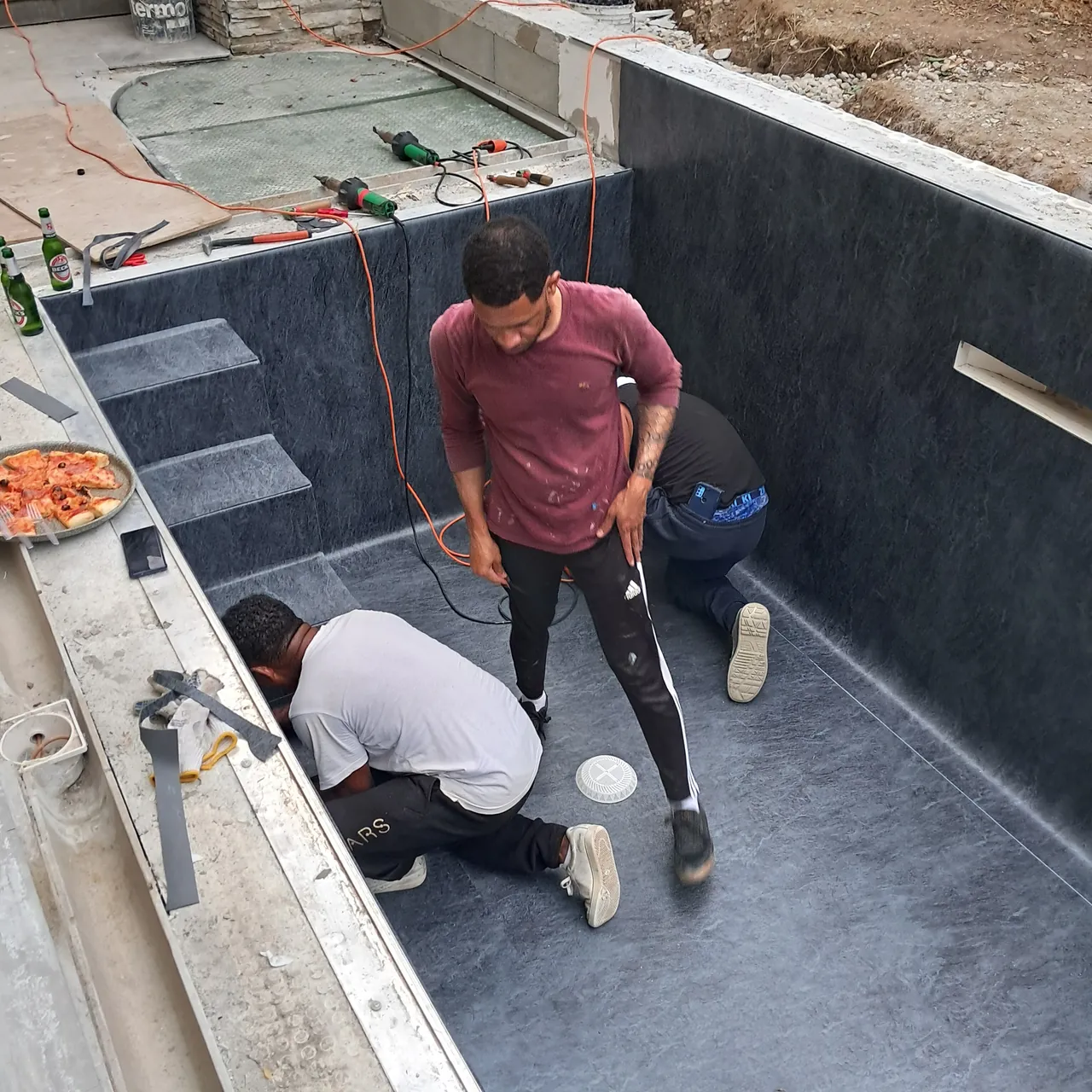 Posa del rivestimento scuro nella vasca e sui gradini
