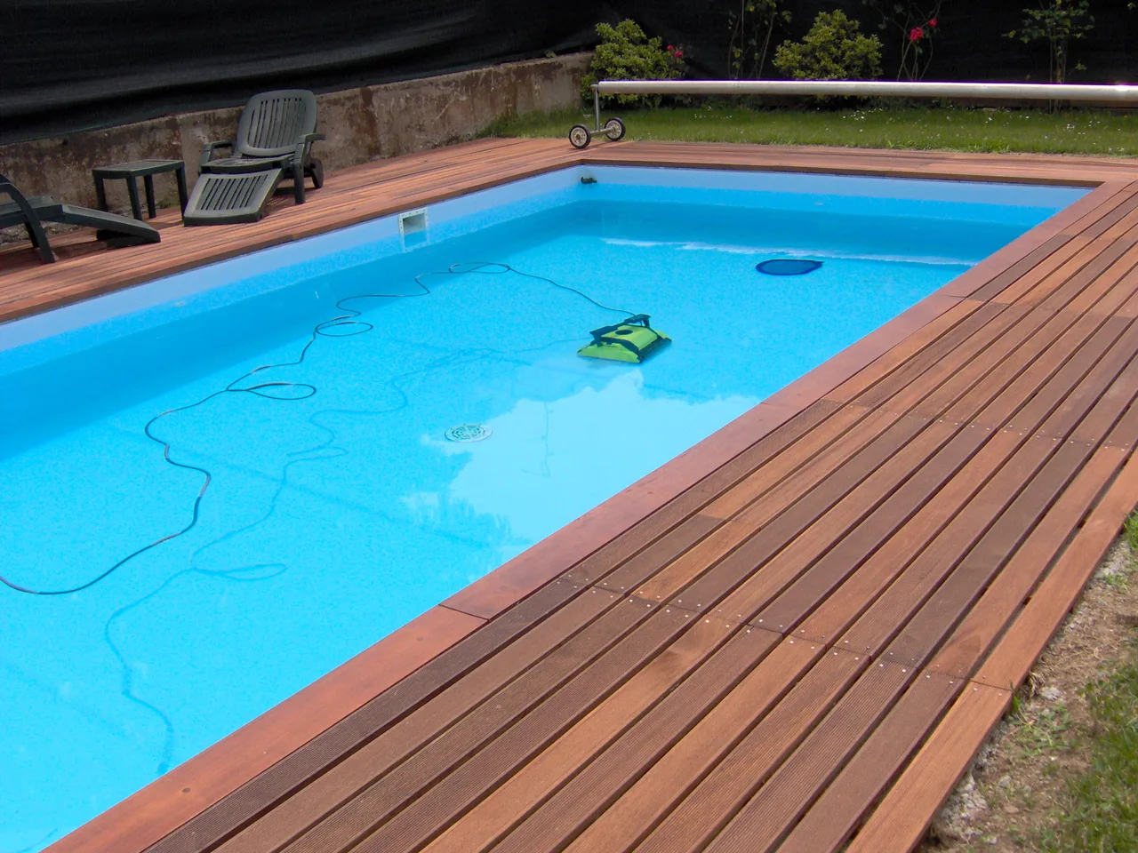 Piscina rettangolare con solarium in legno