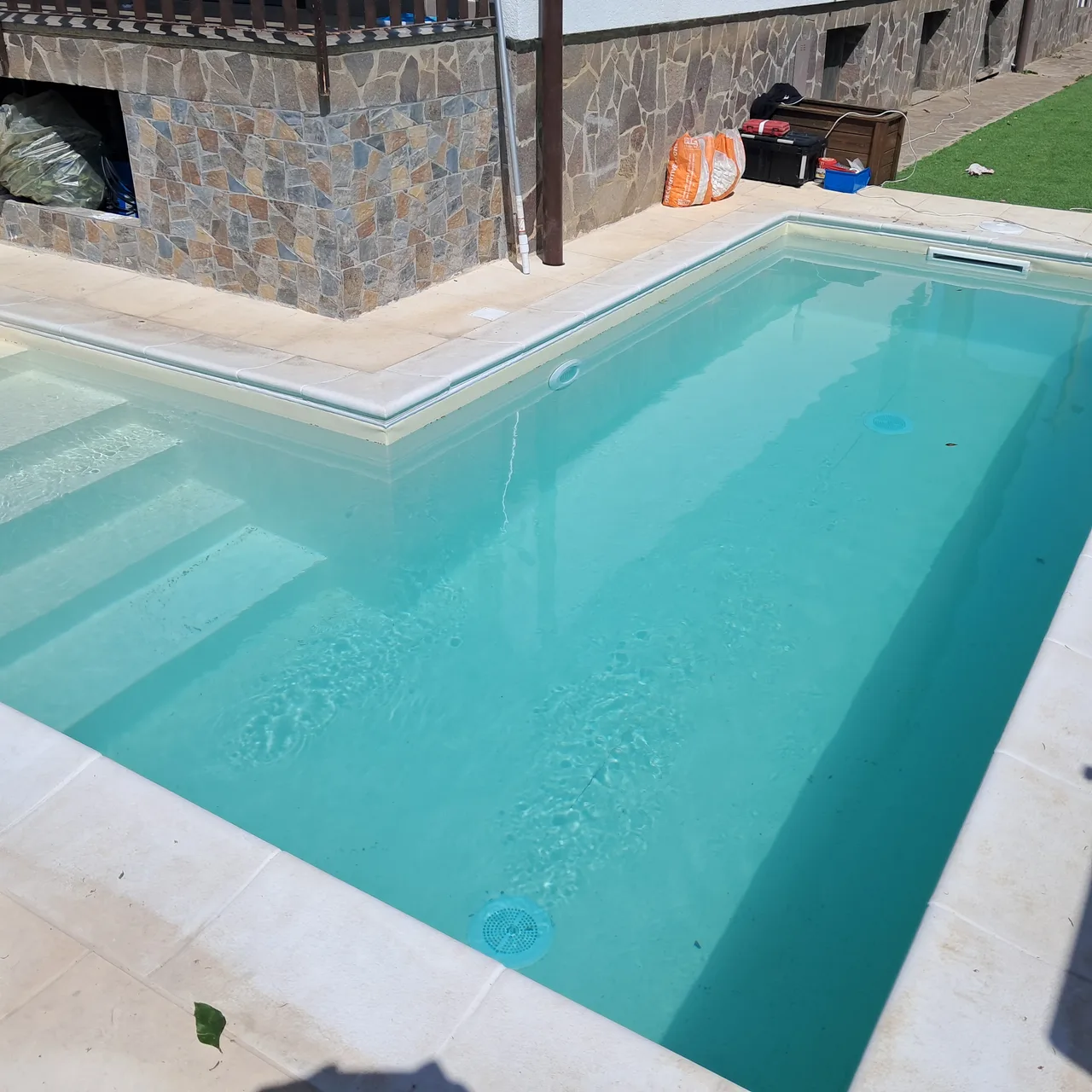 Acqua azzurra e gradini accanto a una parete in pietra